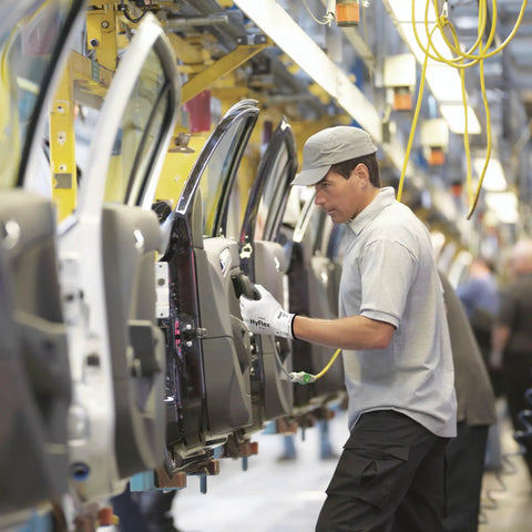 Worker installing a car door on an assembly line wearing HyFlex 11-800 Nylon Glove With Gray Foam Nitrile Coating, Size 8 Medium.