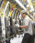 Worker wearing size 6 X small nylon glove with foam nitrile coating for oil grip during assembly line work.