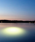 Sick Underwater Led Dock Light With Heavy Duty Fish Attraction Glow illuminating the water at night near a dock.