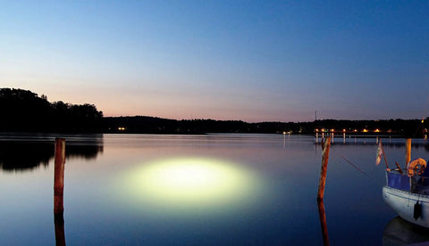 Sick Underwater Led Dock Light With Heavy Duty Fish Attraction Glow illuminating the water at night near a dock.