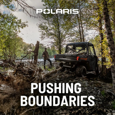 Off-road vehicle navigating through forest terrain, showcasing Polaris adventure capability; man observing beside ATV.