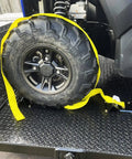 Beefed Up Heavy Duty Wheel Chock Tie Down Kit With 4500 Lb Break Strength securing an ATV tire on a trailer with yellow strap