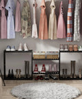 Stylish closet with dresses hanging above black racks with shoes and baskets, over a round rug.