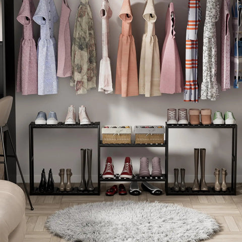 Stylish closet with dresses hanging above black racks with shoes and baskets, over a round rug.