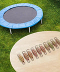 Heavy Duty Extension Springs 10 Pack Steel Coil Load Up To 50kg For Garage Doors Trailer Ramps Farm Gear Durable Carbon Steel Build That Holds Tight arranged on a table with a trampoline in background.
