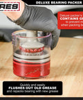 ARES 54036 two-piece bearing packer kit with red grease in a clear housing, gloved hand operating (front view)