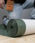 Top Shelf Premium Underlayment One Hundred Square Foot Roll Heavy Duty Moisture Blocker And Impact Noise Reducer on floor.
