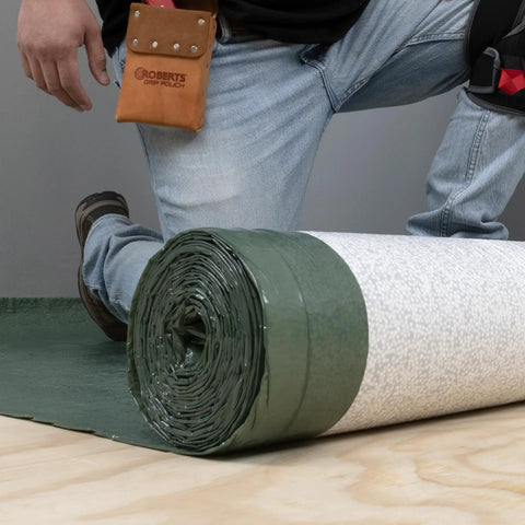 Top Shelf Premium Underlayment One Hundred Square Foot Roll Heavy Duty Moisture Blocker And Impact Noise Reducer on floor.