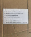 Warning label with safety instructions in multiple languages on cardboard packaging