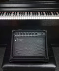 20 Watt Keyboard Amplifier With Dual 8 Inch Woofer And 2 Inch Tweeter AUX In And Two Channel Output placed in front of piano