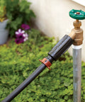 3-In-1 Drip Irrigation Faucet Adapter With Filter, Pressure Regulator And Drip-Lock connected to garden tap with black tubing