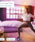 Person doing yoga in a living room with ambient lighting from 60W Equivalent A19 Smart LED Bulbs With RGB Color Changing, Tunable White.