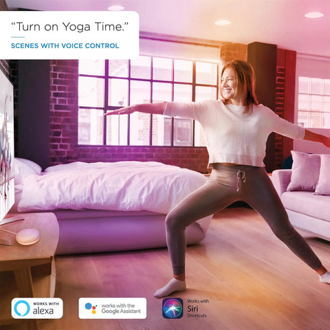 Person doing yoga in a living room with ambient lighting from 60W Equivalent A19 Smart LED Bulbs With RGB Color Changing, Tunable White.