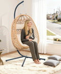 Cozy Hanging Egg Chair With Stand And Plush Cushions for indoor use, featuring a natural wood finish and modern boho style.