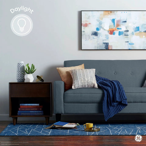 Living room with blue sofa, art piece on wall, and daylight lighting from A15 LED Light Bulb 4.5W Daylight Dimmable, 350 Lumens