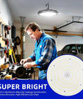 Man working in garage under Two Pack 150W LED High Bay Light 5000K UFO Fixture with US Plug, illuminating work area.