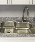 Single-Handle Pull-Down Kitchen Faucet With Sprayer In Satin Nickel installed over a stainless steel sink in a modern kitchen setting.