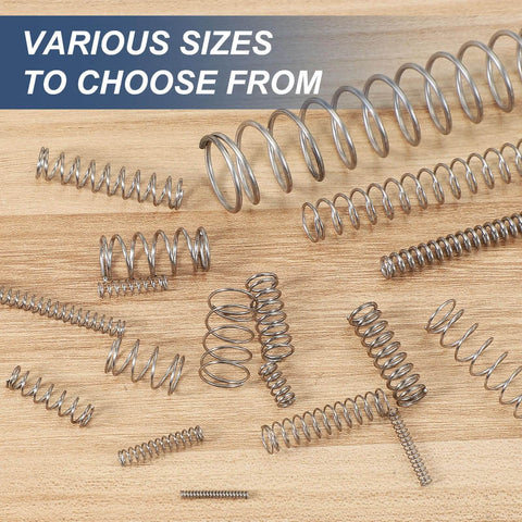 Various stainless steel springs including 2 Mm Outer Diameter 0.3 Mm Wire 10 Mm Free Length Stainless Steel Compression Spring Pack Of 10 For DIY Projects Home Repairs Small Extension Spring 304 Silver Tone displayed on a wooden surface