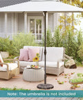 Beefy 30 Lb Umbrella Base With Adjustable Knob For 1.5 To 1.9 Inch Poles supporting a patio umbrella in a garden setting