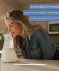 Woman using Drug Free Steam Inhaler For Sinus Congestion And Allergies With Quick 3 To 5 Minute Setup Ultra Quiet Face Steamer on counter