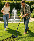 Manual Lawn Aerator Tool With T Handle And Stainless Steel Spikes For Deep Soil Loosening in garden near a fountain.