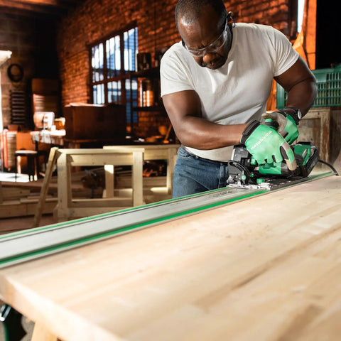 Person using C3606DPA cordless track saw kit with 63 inch extruded aluminum track for precise clean cuts on wood