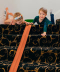 Children playing with Flexible 15 Foot Race Car Track For Kids With Suction Cups on stairway carpet
