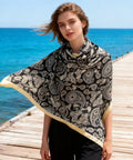 43 Inch Square Silk Feeling Scarf For Hair And Neck Wrap worn as a shawl, lightweight satin polyester blend, 110cm by 110cm, on a boardwalk.