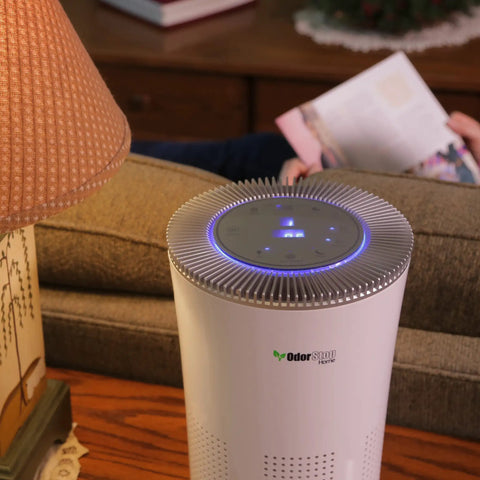 Premium Hepa Air Purifier With H13 True Filters And Uv Light Plus Activated Carbon on a table beside a lamp.