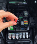 Hand placing a red fuse from 120 Piece Blade Fuse Kit For Cars Trucks Boats And RVs With Color Coded Housings And Clear Amp Ratings