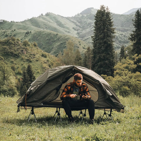 Man sitting in Camping Cot Tent Combo For Solo Adventures Waterproof Off Ground Bed For Adults 1 Person Ultra Portable Easy Setup