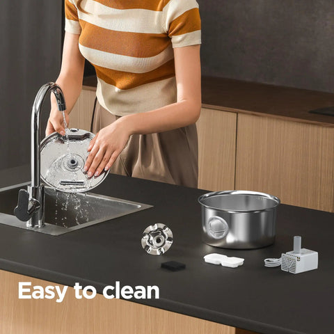 Woman cleaning Stainless Steel Cat Water Fountain Two Point Six Liter Ultra Quiet Pet Fountain parts on kitchen sink.