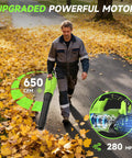 Man using Cordless Leaf Blower With Dual 5.2Ah Batteries And Charger 650 CFM Electric Blower on pathway surrounded by autumn leaves
