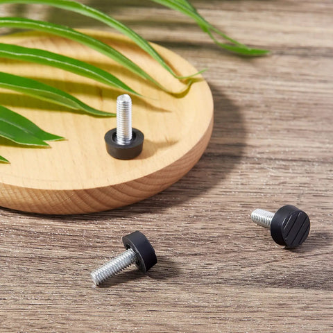 Forty Piece Heavy Duty M6 Thread Adjustable Furniture Levelers And Screw In Feet To Squash Wobbly Tables And Chairs Quick With Grip Tight Glides That Stop The Wobble Forever For Indoor Or Outdoor Setup close-up of three black levelers on wood surface.