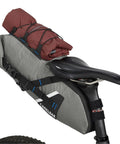 Mule 9 Bikepacking Rolltop Waterproof Saddle Bag For Tents And Gear With IPX5 Rating on bike, loaded with red tent, Wolf Grey 2.0.