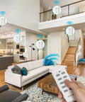 Hand using remote in living room to control Remote Control Outlet Set With Two Remotes And Five Outlets, No Fuss Wireless On Off Power Switch Kit