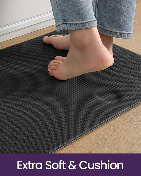 Person standing on Cushioned Anti Fatigue Kitchen Floor Mat 23x59 Inch Wide Runner Rug With Memory Foam Padding Waterproof Design For Front Sink And Laundry Ergonomic Standing Mat To Relieve Foot And Leg Fatigue Black