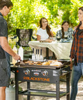 Outdoor barbecue setup with grilling tools on flat-top griddle, Magnetic Design 10 Inch Griddle Spatula Holder Stainless Steel Tool Rack visible.