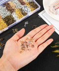 Hand holding mini screw eye pins from 600 Pieces Screw Eye Pins Hooks Set In 6 Colors And 3 Sizes 4x8mm 5x10mm 6x13mm Metal Eyelets