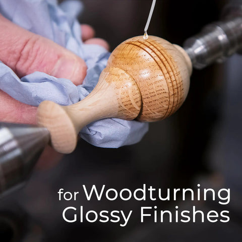 Applying finish to wooden object on lathe for woodturning glossy finishes.