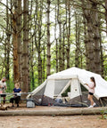 Ten Person Instant Cabin Tent With Built In Led Lighting And Pop Up Setup Large Lighted Camping Tent For Outdoor Adventures Glamping Or Backyard Use Includes Storage Pockets For Gear in a forest setting with people around.