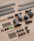 Heavy Duty 4Ft Bypass Sliding Barn Door Hardware Kit Built Tough For Two Doors Single Track System With Smooth Quiet Glide Top Mount Hangers Rust Resistant Black Steel Rail Ideal For Farmhouse Or Modern Living Spaces Door Not Included components including tracks and hangers spread on a wooden floor.