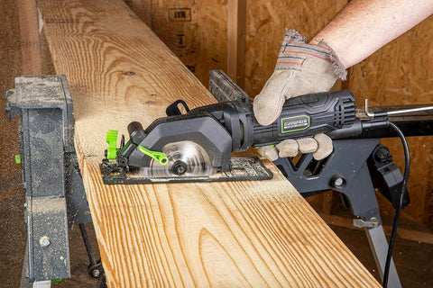 Person using Genesis Mini Circular Saw 4.0 Amp 4-1/2 Inch With 24-Tooth Carbide Blade for precise cut on wood.