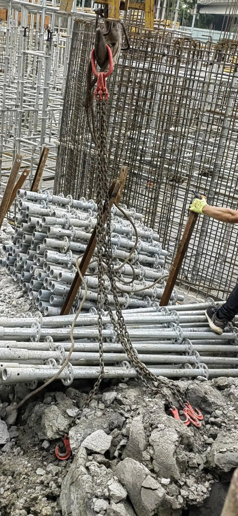 Kick Butt Heavy Duty Chain Lifting Sling 4 Leg 3 Ton 6614 Lbs Capacity with chains and hooks lifting pipes on construction site.
