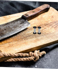 Heavy Duty Stainless Steel Bindery Rivets And Self Tapping Metal Handle Screws on wooden cutting board beside knife.
