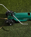 Traveling sprinkler system on grass showing tractor wheel, gear housing, and sprinkler arms in silver and green finish.