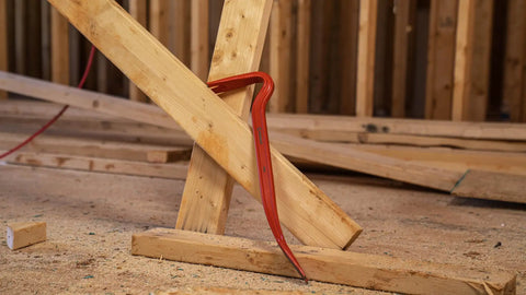 30-Inch Steel Wrecking Bar Heavy Duty Demolition Pry Tool for Contractors and DIY Pros Built Tough for Industrial and Home Use Meets ANSI and ASME Specs demonstrating leverage on wooden beams