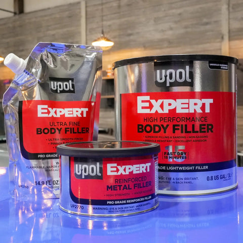 Front view of Expert Reinforced Metal Filler With Aluminum Reinforcement For Built Tough High Strength And Heat Resistant Auto Repairs Durable Automotive Repair Filler 237 Milliliters, along with other body fillers on a table.