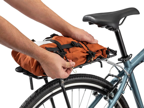 Person attaching orange bag to Rear Bike Rack For Everyday Hauls Lightweight Durable Cargo Carrier With 26 Lb Capacity That Fits Most Adult Bikes.