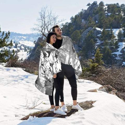 Couple using Emergency Mylar Space Blanket 4 Pack For Outdoors Survival Camping Hiking Go Bags And First Aid Kits Reflective